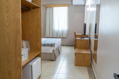 a small room with a bed and a television at Hotel Dan Inn Franca & Convenções By Nacional Inn in Franca