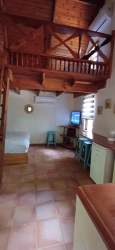 a room with a loft with a bed and a tv at חווה של דני in Bet Hillel