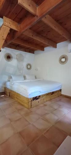 a bedroom with a wooden bed in a room at חווה של דני in Bet Hillel