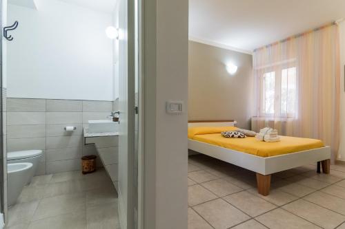 1 dormitorio con cama amarilla y baño en B&B Belvedere, en Agropoli
