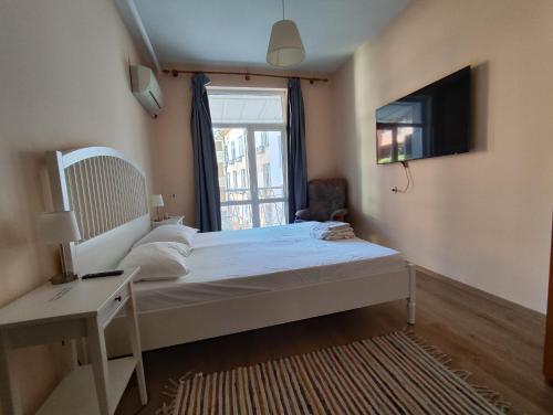 a bedroom with a bed with a television and a window at Podslon Varna Vibes in Varna City