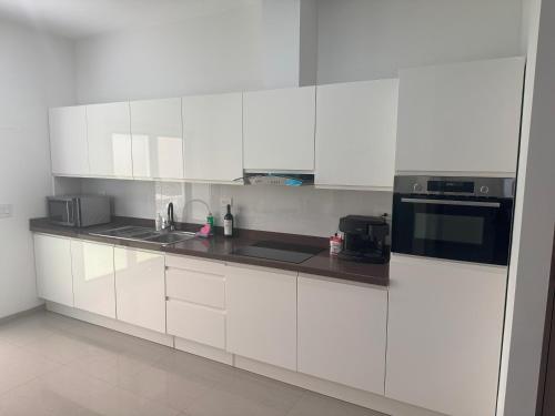 a white kitchen with white cabinets and appliances at Blissful Bubali Apartment Aruba in Palm-Eagle Beach