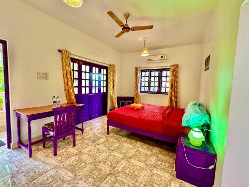 a bedroom with a bed and a desk and a table at Dreamy vibe Stays in Morjim