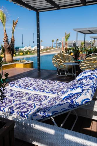 a bed on a deck with a pool in the background at Caspi Mayr in Baku