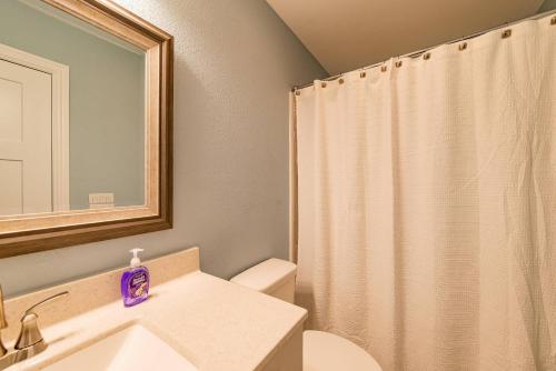 a bathroom with a sink and a shower curtain at Kilmarlic Bubba Watson in Powells Point