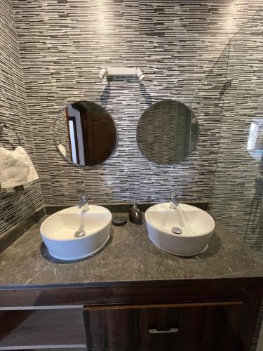 a bathroom with two sinks and two mirrors on a counter at Diaft'na in Marrakech