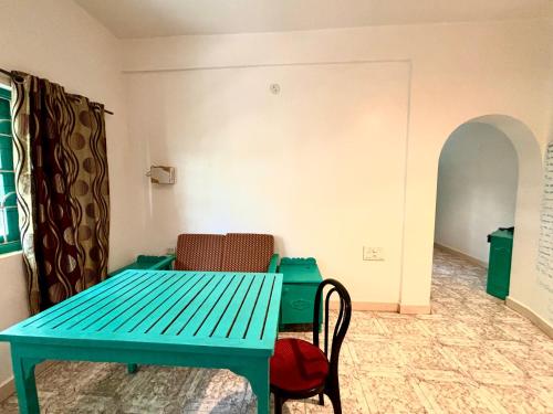 a blue table and chairs in a room at Dreamy vibe Stays in Morjim