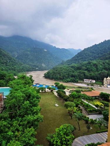 a view of a river with mountains in the background at Aloha Apartments by blissful Ganges in Rishīkesh