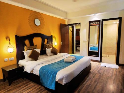a bedroom with a large bed and a mirror at Aloha Apartments by blissful Ganges in Rishīkesh