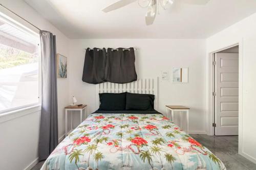 a bedroom with a bed with a floral bedspread at Cozy Volcanic Rainforest House in Volcano