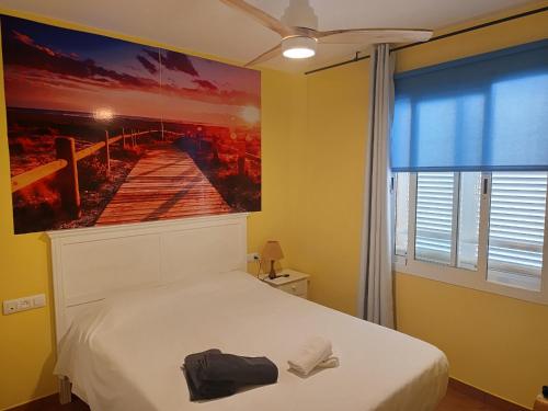 Un dormitorio con una cama con un cuadro en la pared. en apartamento Isleta del Moro, Cabo de Gata, en La Isleta del Moro