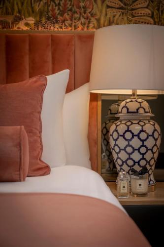 a bed with a lamp on a table with a pillow at HYDE Hotel in Galway