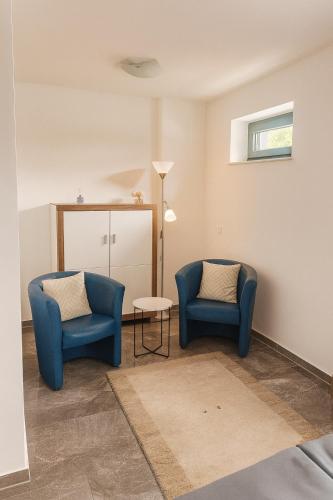 two blue chairs and a table in a room at Ferienapartment Münster in Münster