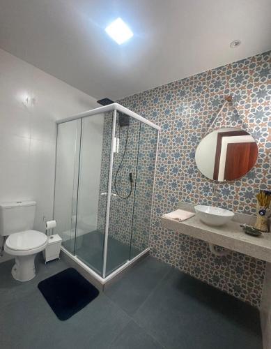 a bathroom with a shower and a toilet and a sink at Pousada Vista Grega in Arraial do Cabo