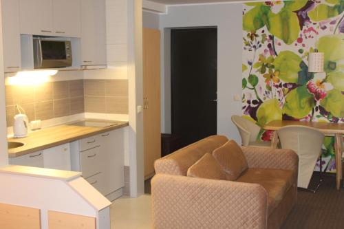 a kitchen and a living room with a couch and a table at Broliu Vila in Druskininkai