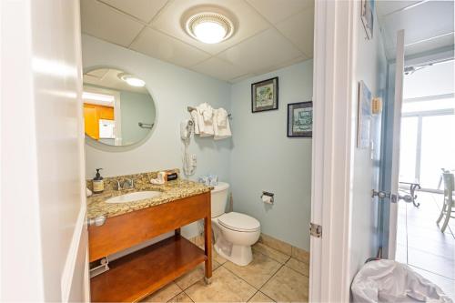 um banheiro com uma pia, um vaso sanitário e um espelho em Honeymoon Suite, Direct Oceanfront Suite, Pools! em Myrtle Beach