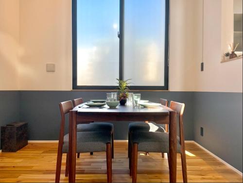 a dining room with a table and chairs and two windows at UKIYO BLUE-羽田空港6分-品川駅7分-最大10名貸切一軒家-100inchスクリーン完備 in Tokyo