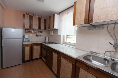 a kitchen with a white refrigerator and a sink at Apartment Anne in Crikvenica