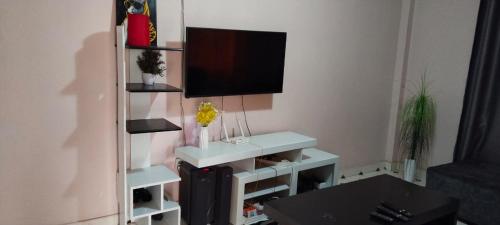 a living room with a tv and a white table at Flex Zone in Nairobi