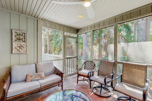 a screened in porch with a couch and two chairs at 1038 Sparrow Pond in Kiawah Island