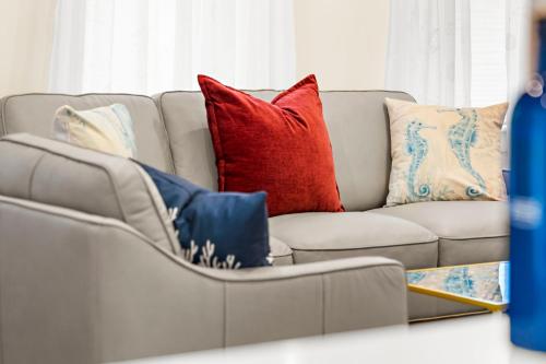 a couch with pillows on it in a living room at The Seafarers Stay A Nautically Themed 3BR Flat in Stonington Borough in Stonington