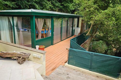 a house with a green fence on a wooden deck at Beautiful loft for 4 with large terrace 