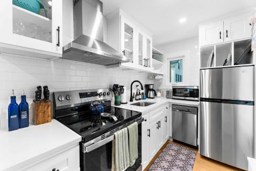 a kitchen with white cabinets and stainless steel appliances at The Seafarers Stay A Nautically Themed 3BR Flat in Stonington Borough in Stonington