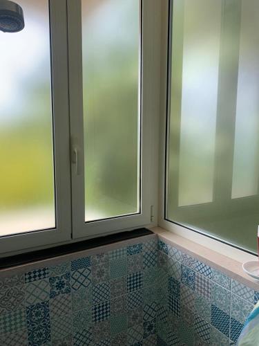 a bathroom with two windows and a tiled floor at Costa Trabocchi appartamento sul Mare in Fossacesia