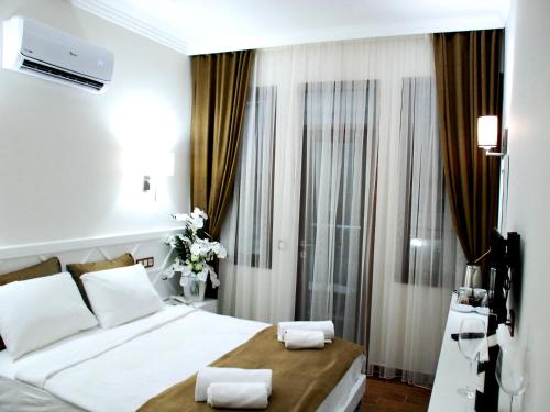 1 dormitorio con 1 cama grande y toallas. en Elegance Hotel Kemer en Kemer