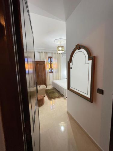a bedroom with a bed and a mirror on a wall at Diaft'na in Marrakech