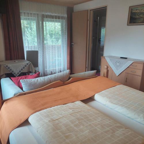 a bedroom with two beds and a window at Landgasthof Hubertusstubn in Sankt Michael im Lungau
