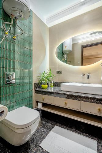 a bathroom with a toilet and a sink and a mirror at Tree of Life Bed & Breakfast in New Delhi