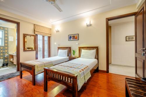 a bedroom with two beds and a bench in it at Tree of Life Bed & Breakfast in New Delhi
