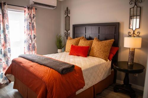 a bedroom with a large bed with orange pillows at Priceless on Price St Walk to downtown! in Mount Airy
