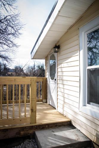 a wooden porch with a door on a house at Priceless on Price St Walk to downtown! in Mount Airy