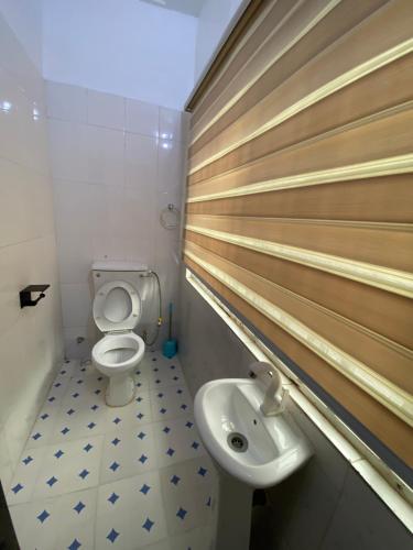 a bathroom with a toilet and a sink at Amors Apartments in Gwarinpa