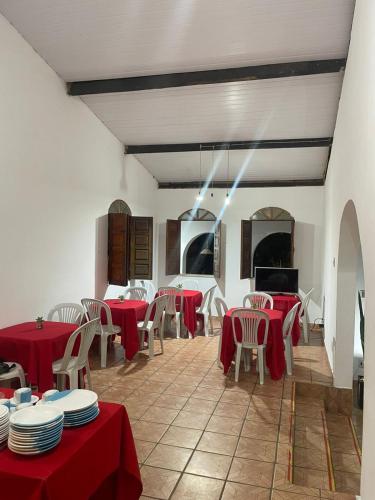 a restaurant with red tables and chairs and a fireplace at Pousada Raizes de Lencóis in Lençóis