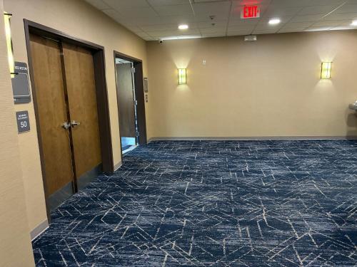 an empty hallway in a office building with a blue carpet at Comfort Inn & Suites Near Lake Guntersville in Scottsboro