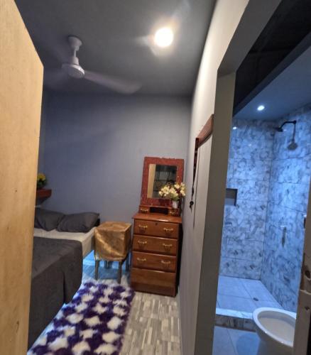Un dormitorio con una cama, un lavabo y un espejo. en habitación para 1, en Iquitos