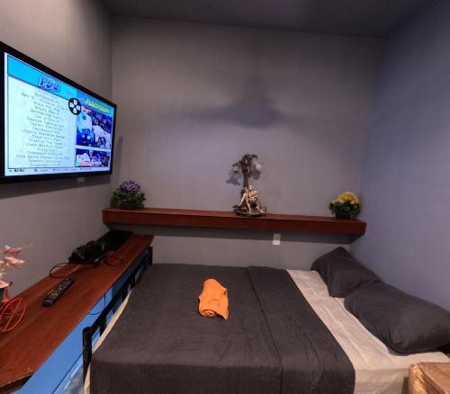 Un dormitorio con una cama y un televisor de pantalla plana. en habitación para 1, en Iquitos
