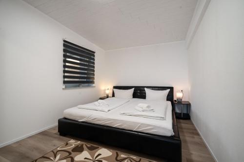 a bedroom with a bed with white sheets and a window at Ferienhaus Kira in Rechlin