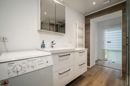 a kitchen with white cabinets and a sink at Ferienhaus Kira in Rechlin