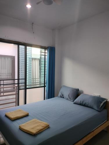 a bedroom with a bed with two towels on it at DEN NEST Guest House Krabi in Ban Khlong Chi Lat