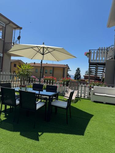 a table and chairs with an umbrella on a lawn at Relaxing Home in Tignale