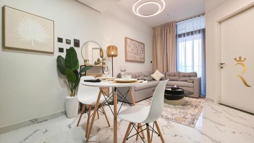 a living room with a table and white chairs at Cozy 1BR Oasis - Luxe Chic Retreat in Abu Dhabi