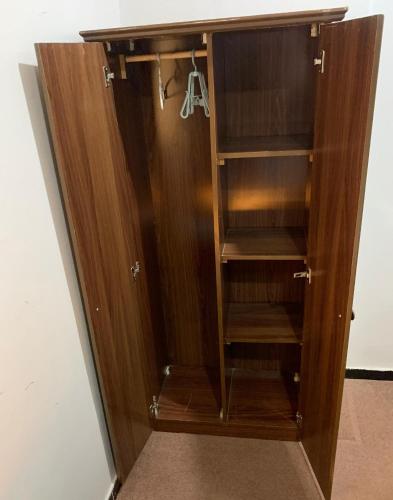 a wooden cupboard with a door and shelves at فندق ألماس المغرب العربي - Almas Maghreb Hotel in Makkah
