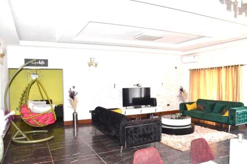 a living room with a green couch and a swing at Chic Modern Getaway in Freetown