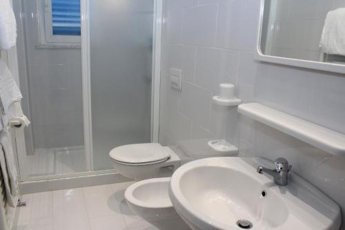 a white bathroom with a toilet and a sink at Aparthotel Villa Marinù in Ischia