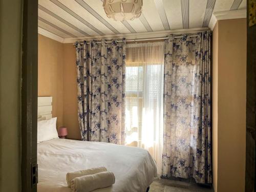 a bedroom with a bed and a window with curtains at 17 Zurich Drive House in Margate