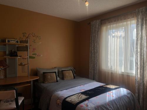 a bedroom with a bed and a window at citadel cozy quilt private bedroom in Calgary